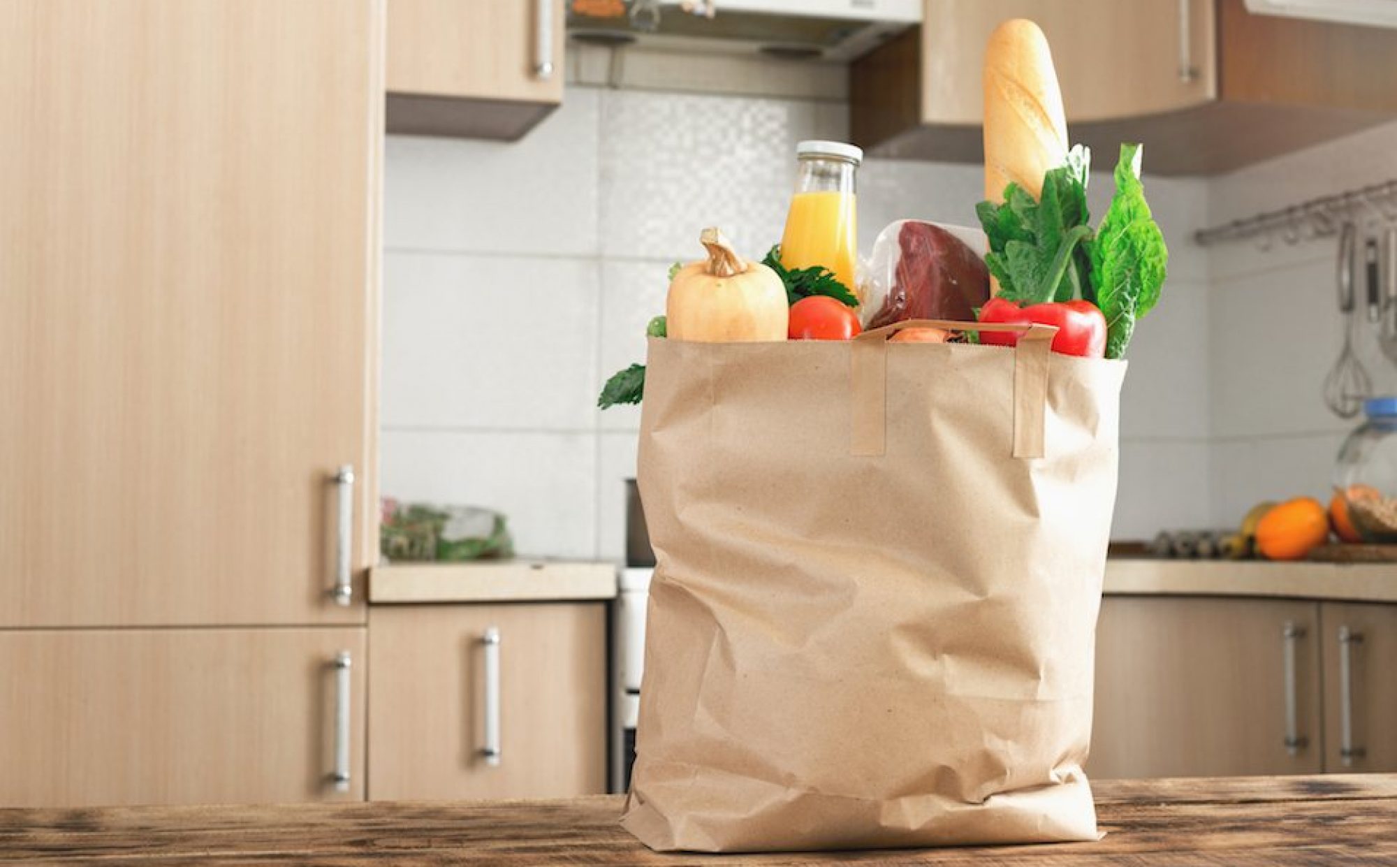 cropped-Paper-bag-full-of-healthy-food-on-a-wooden-table-in-the-kitchen